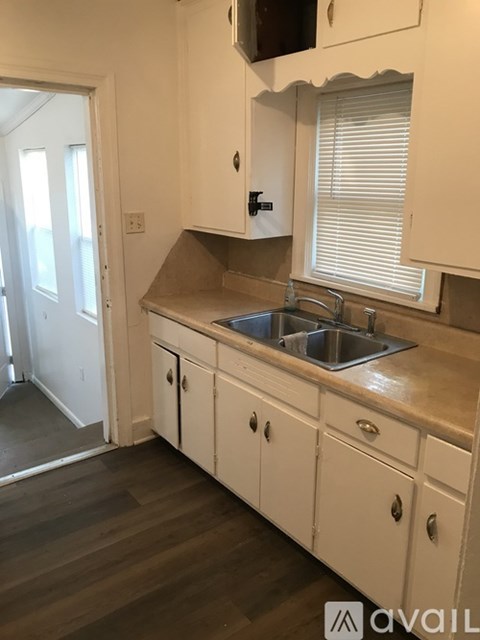 A kitchen with white cabinets and a sink.