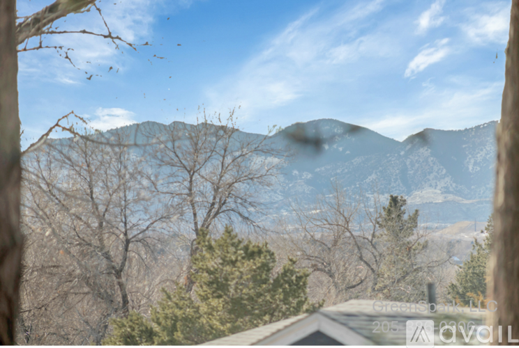 A mountain range is seen through the trees in the distance.