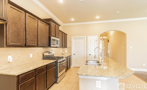 A kitchen with brown cabinets and a granite countertop.