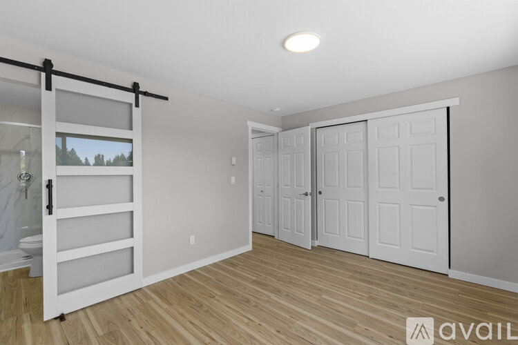 A room with a sliding door and a window with a view of trees.