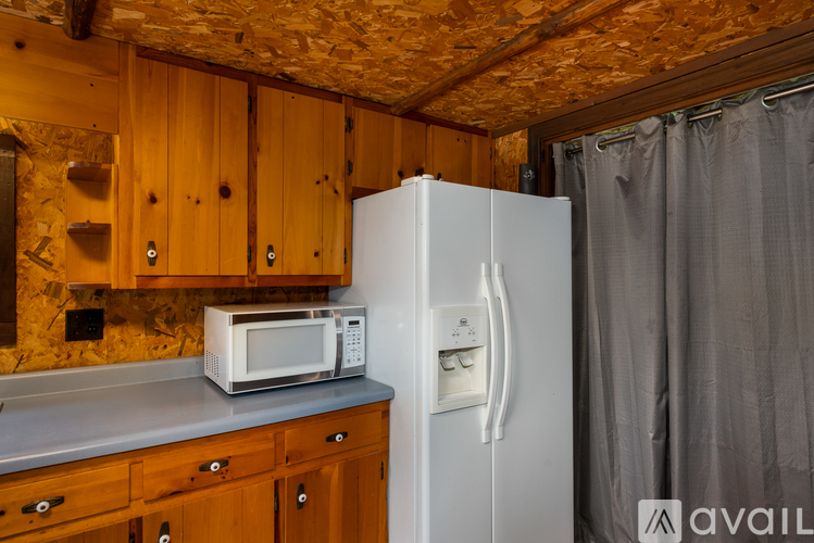 A kitchen with wooden cabinets and a white fridge.