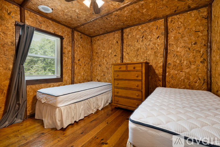 A bedroom with two beds, one with a white mattress and the other with a blue mattress.