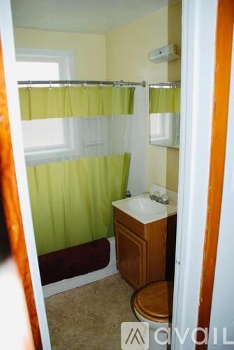 A small bathroom with a toilet, sink and shower.