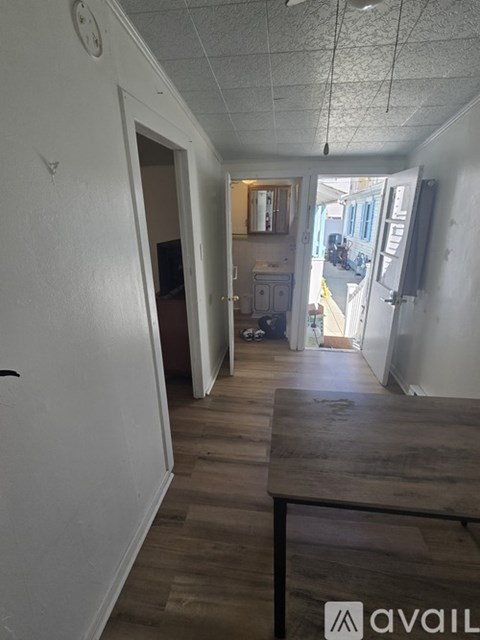 A hallway with a wooden floor and white walls.