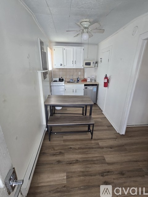 A kitchen with a wooden floor and white walls.