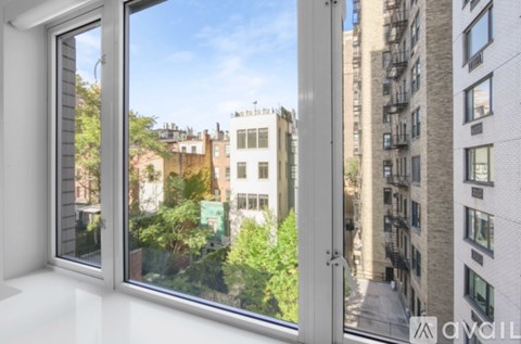 A view from a window looking out at a city street.