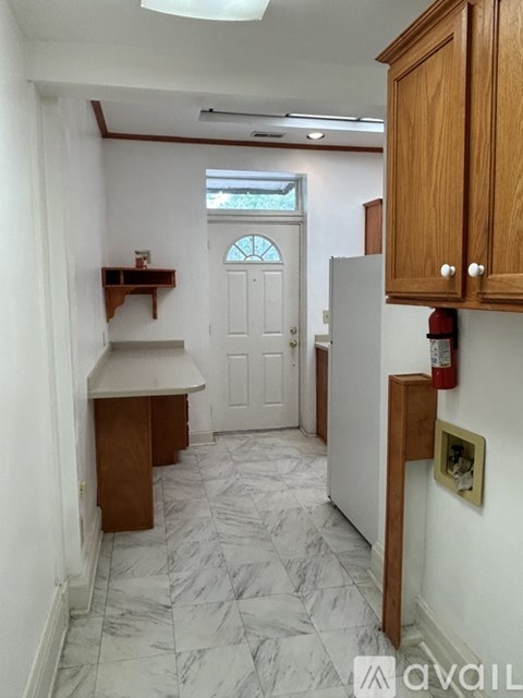 A kitchen with a white door and a marble floor.