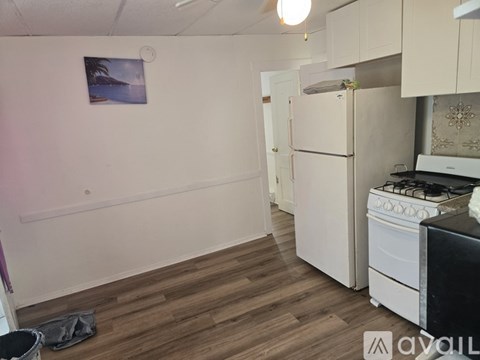 A kitchen with a white refrigerator and a black stove top oven.