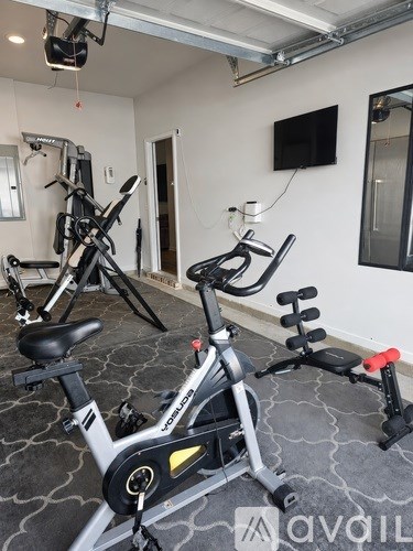 A gym with exercise bikes and a television.