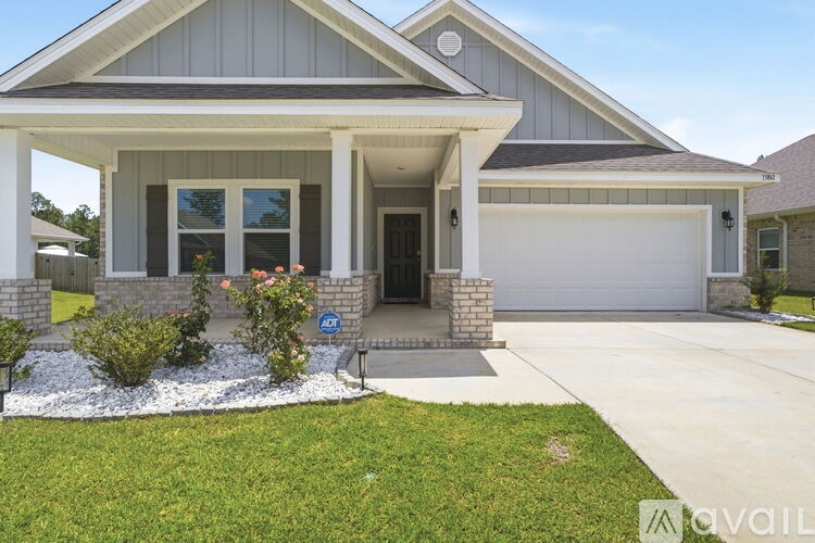 A house with a grey roof and a white garage door.