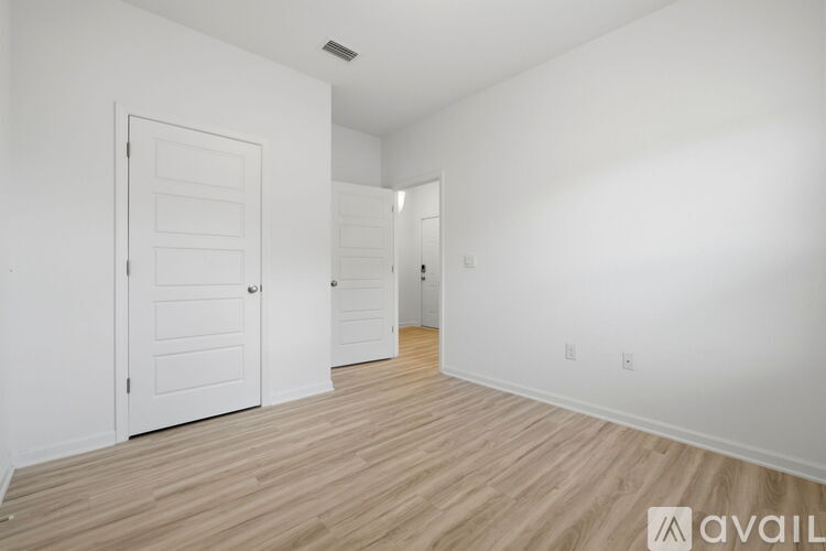 A room with a white door and a white wall.