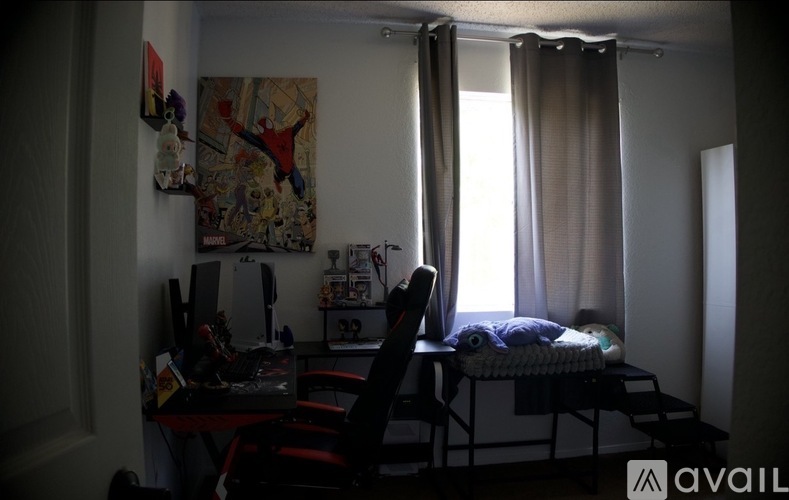 A room with a desk, chair, and a bed.