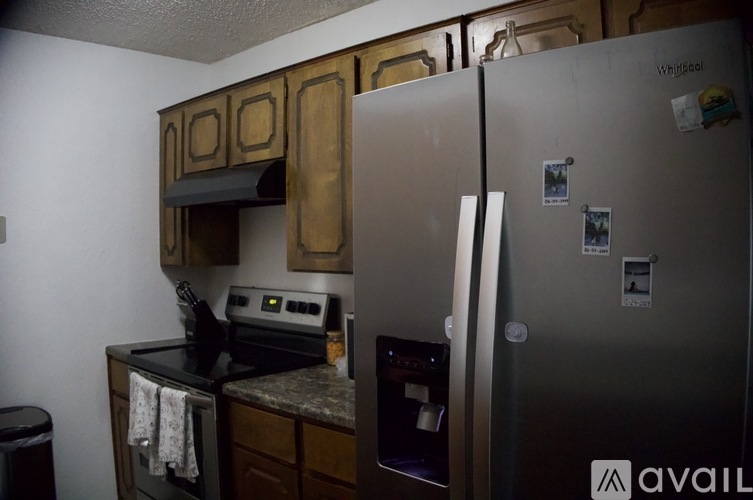 A kitchen with a refrigerator, oven, and cabinets.