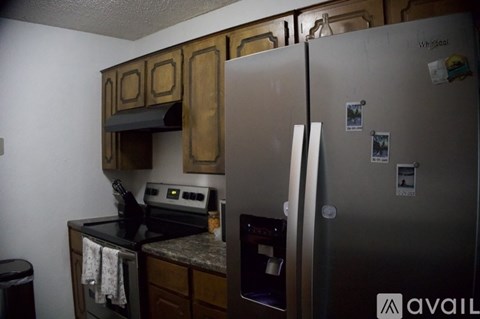 A kitchen with a refrigerator, oven, and cabinets.