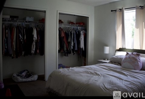 A bedroom with a bed, a wardrobe, and a window.