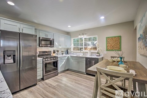 A kitchen with a table set for two and a painting on the wall.