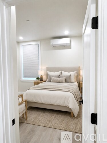 A bedroom with a large bed and a window.