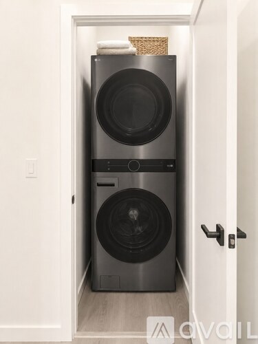 A modern black washing machine and dryer in a white door.