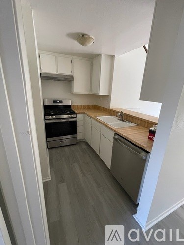 A kitchen with white cabinets and a wooden countertop.