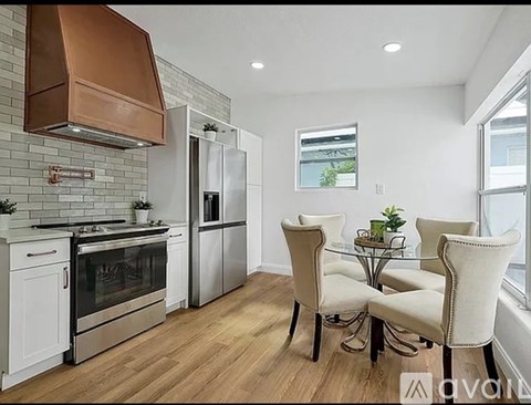 A modern kitchen with a glass table and chairs.