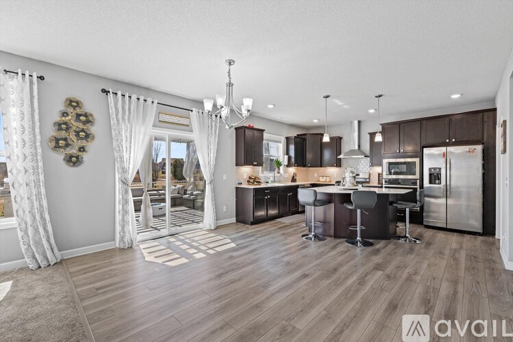 A modern kitchen with a dining area and a living room area.