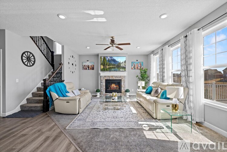 A living room with a fireplace and a staircase.