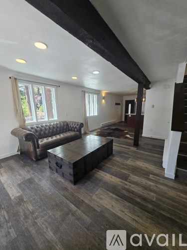 A living room with a brown leather couch and a wooden coffee table.