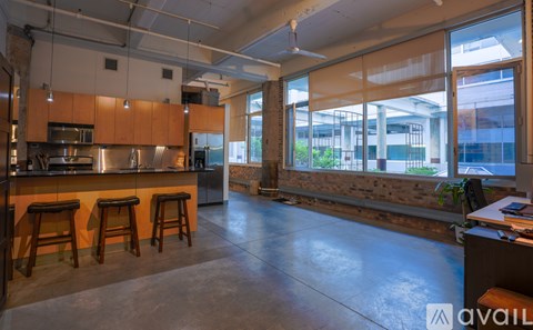 A kitchen with wooden bar stools and a large window.