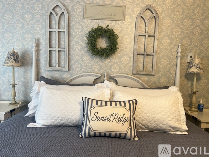 A bed with a pillow that says Sunset Ridge on it.