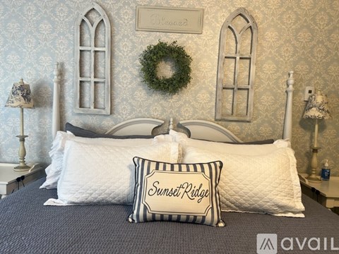 A bed with a pillow that says Sunset Ridge on it.
