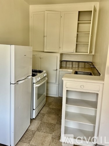 A kitchen with a white refrigerator, white oven, and white cabinets.