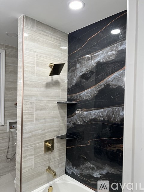 A bathroom with a black and white marble wall.
