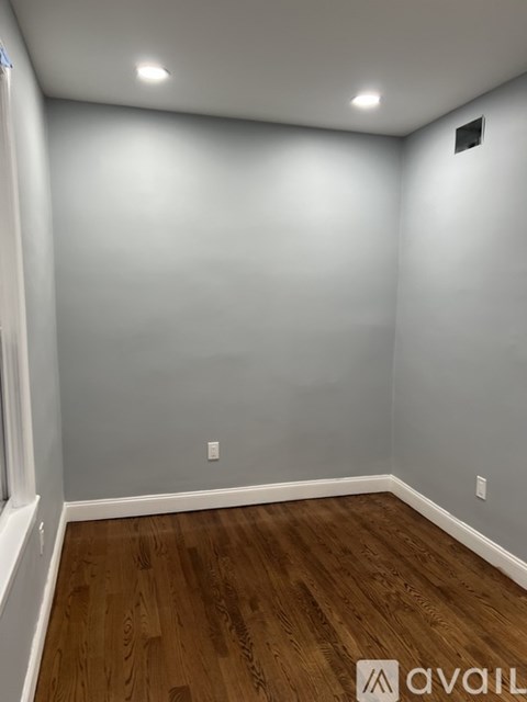 A room with wooden flooring and white walls.