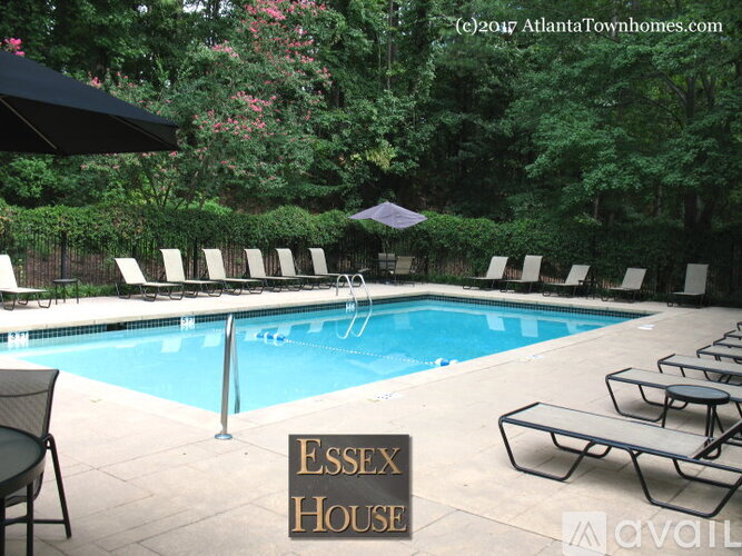 A pool surrounded by trees and chairs with a sign that says Essex House.