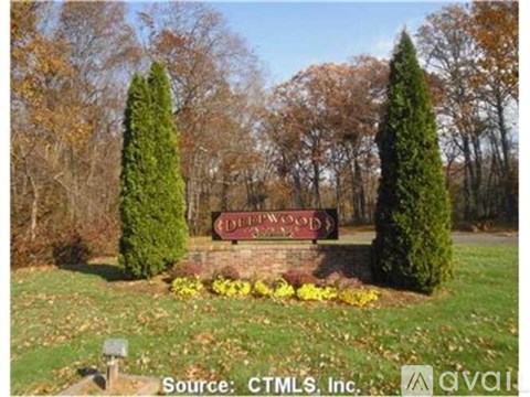 A sign that says Derwood in front of some trees.