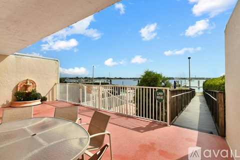 A balcony with a table and chairs overlooking a body of water.