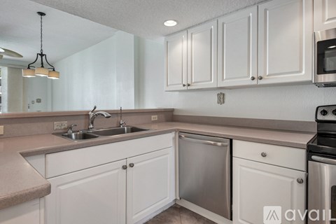 A kitchen with white cabinets and stainless steel appliances.