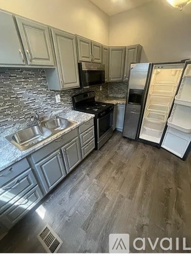A kitchen with a sink, stove, and refrigerator.
