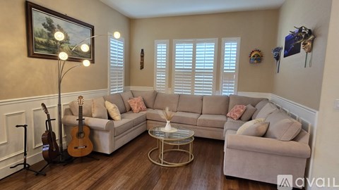 A living room with a guitar and a painting on the wall.