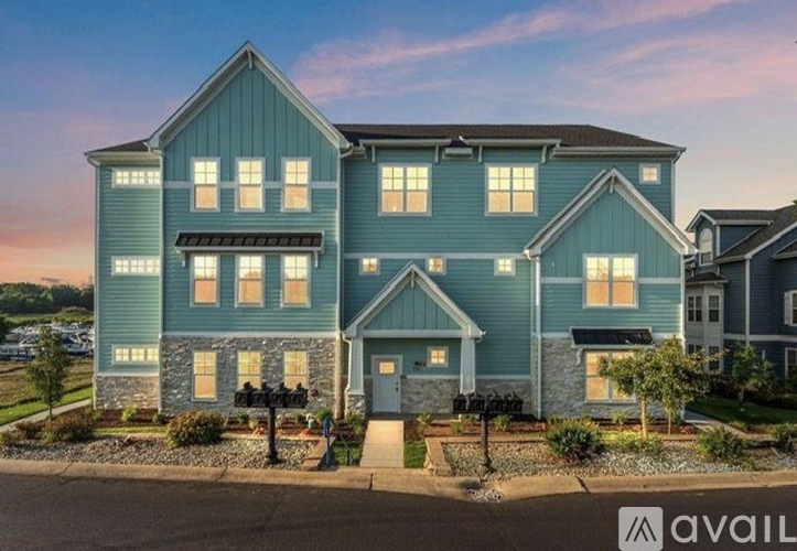 A large blue house with a front yard and a sign that says "available".