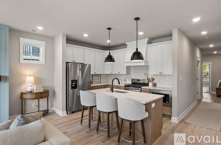 A modern kitchen with a large island and bar stools.