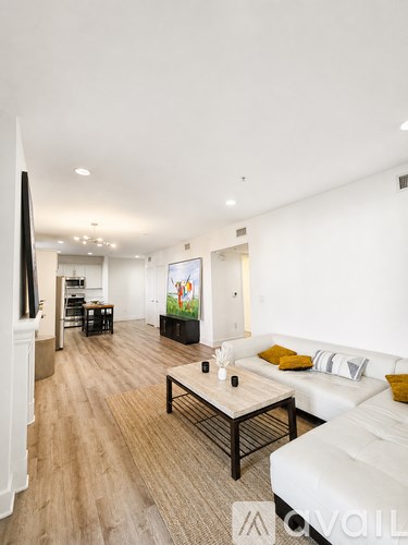 A living room with a white couch and a wooden coffee table.