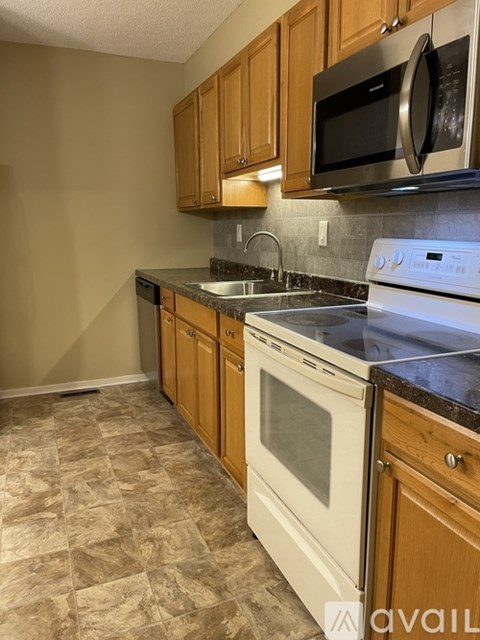 A kitchen with a black microwave above a white oven.