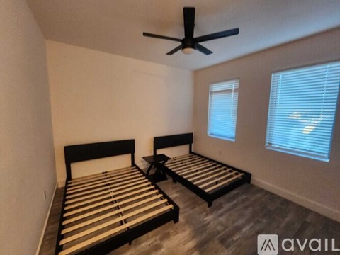 A bedroom with two beds and a ceiling fan.