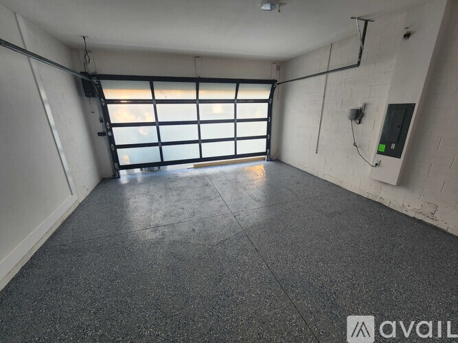 A spacious room with a large window and a concrete floor.
