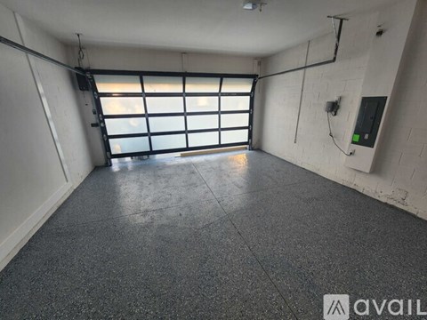 A spacious room with a large window and a concrete floor.