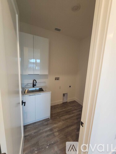 A kitchen with white cabinets and a sink.