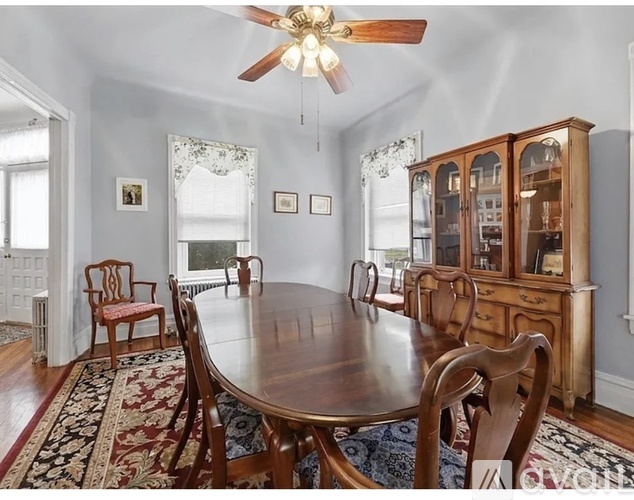 A dining room with a wooden table and chairs.
