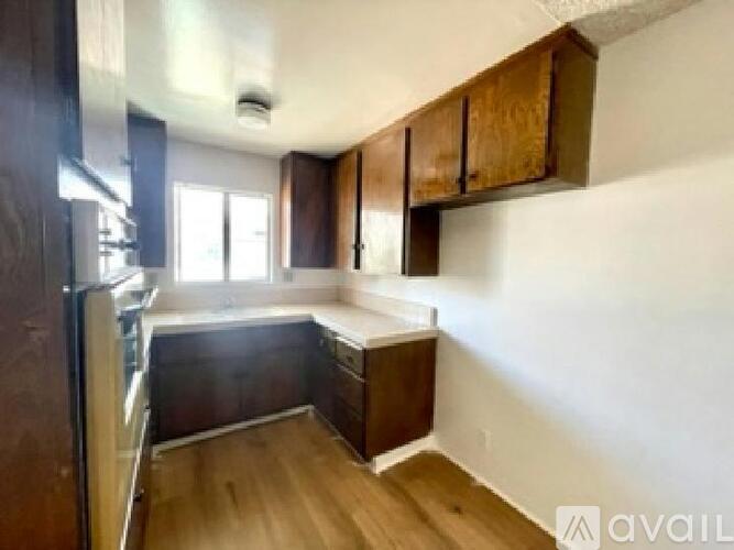 A kitchen with wooden cabinets and a refrigerator.