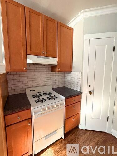 A kitchen with wooden cabinets and a white stove.